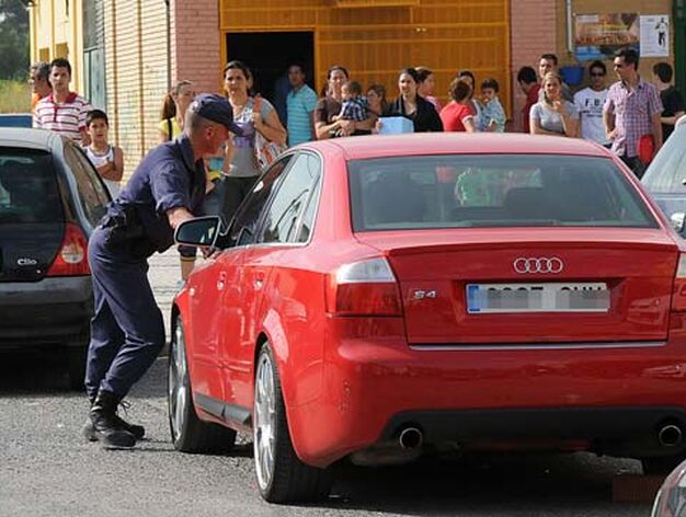 Un agente empuja un coche en doble fila que taponaba el furgon de la Polic&iacute;a.

Foto: Juan Carlos V&aacute;zquez