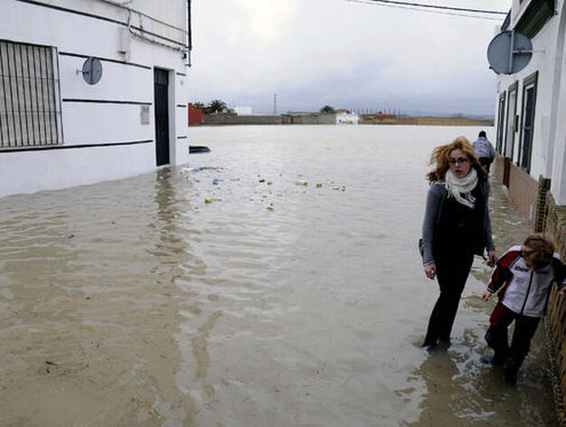 Una mujer y un ni&ntilde;o andan sobre el agua que inunda Tocina.

Foto: Juan Carlos V&aacute;zquez