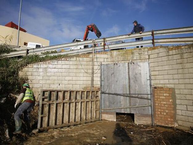Los trabajadores refuerzan la compuerta para evitar nuevas inundaciones en &Eacute;cija ante la previsi&oacute;n de lluvias.

Foto: Antonio Pizarro