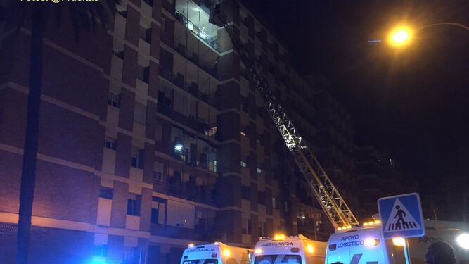 Los Bomberos despliegan la grúa para acceder a los pisos superiores, afectados por el humo.