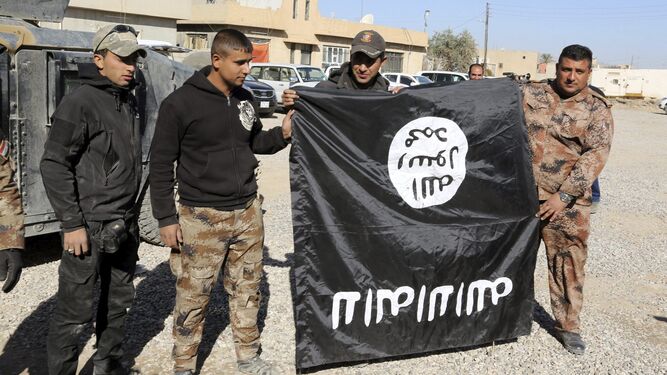 Soldado Chiíes sostienen una bandera de Estado islámico.