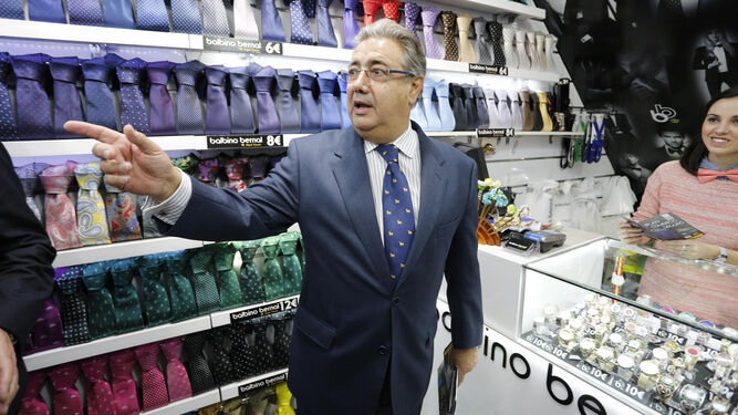 . El  ministro del Interior , Juan Ignacio Zoido, reparte folletos del plan  Comercio  Seguro  en una tienda del centro.