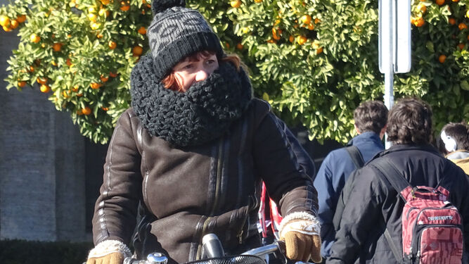 Una mujer se protege del frío con bufanda y guantes.