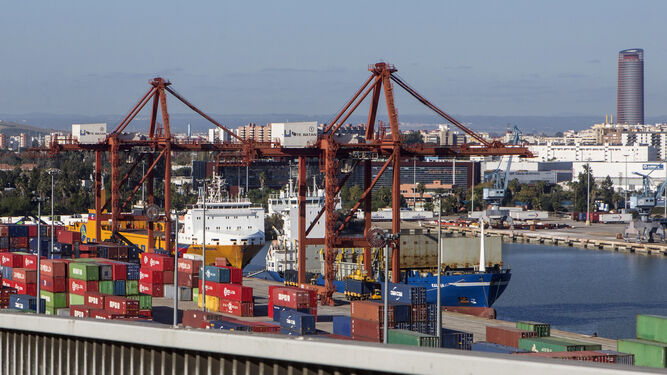 Imagen del Puerto de Sevilla, con sus contenedores, tomada desde la dársena del Batán, con la ciudad y la Torre Pelli al fondo.