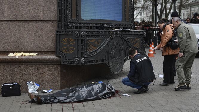 Un agente de la Policía inspecciona la escena del crimen junto al cadáver del ex diputado ruso Denis Voronenkov.