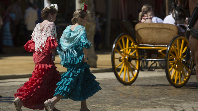 Dos jóvenes flamencas por el real de la feria