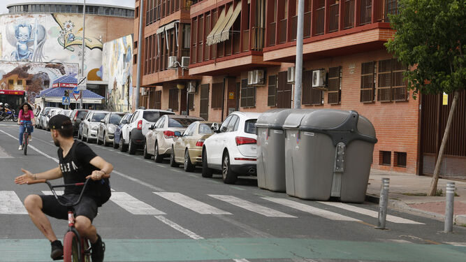Dos jóvenes pasan en bicicleta por la zona en la que ocurrieron los hechos, en la calle Radio Sevilla.