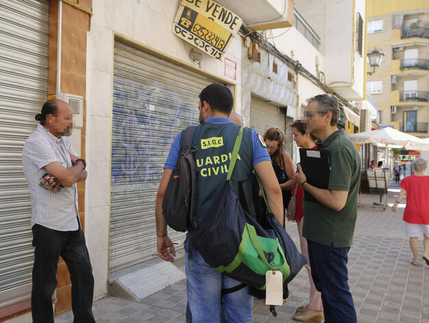 Uno de los sospechosos, custodiado  por la Guardia Civil, durante el registro de un local en la calle Emilio Prados, junto a Pino Montano.
