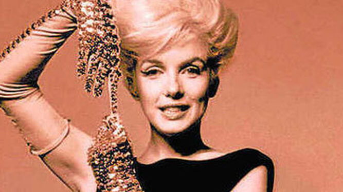 Fotografía de Marilyn Monroe con vestido negro y guantes dorados.