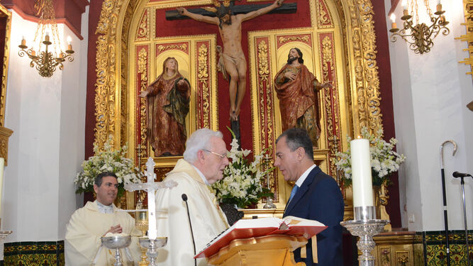 El cardenal Amigo Vallejo le da la paz a José Luis Sanz en presencia del párroco de Tomares, Gregorio Sillero.