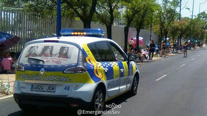 Un coche de la Policía Local, en un tramo de la cola.