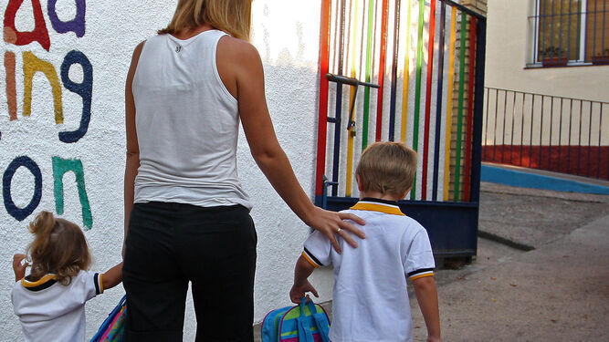 Una madre lleva a sus hijos a una guardería sevillana.