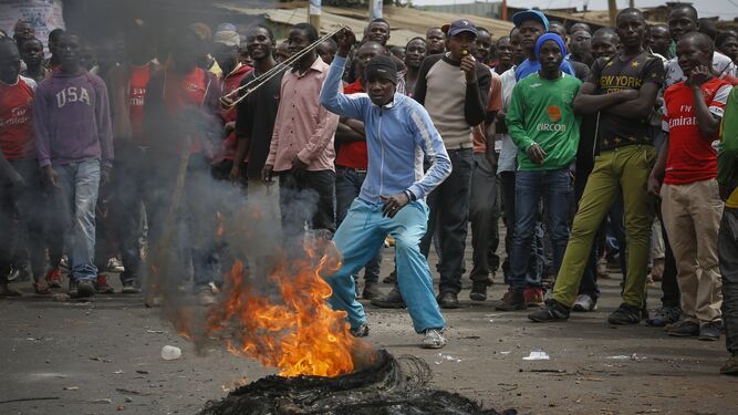 Partidarios del candidato opositor Raila Odinga se congregan frente a un neumático en llamas durante una protesta