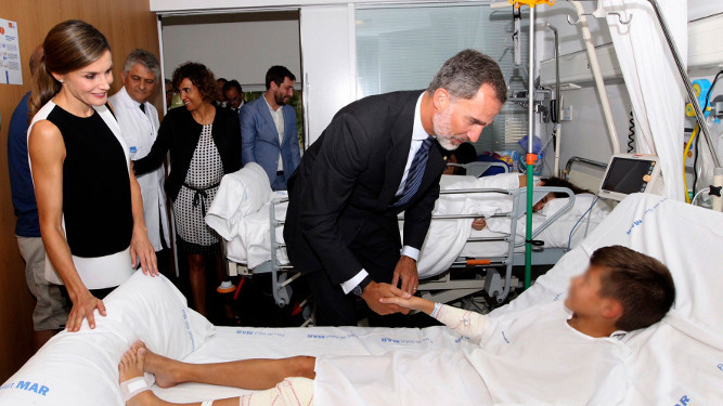 Los Reyes saludan a uno de los niños, víctima de los atentados de Cataluña, durante su visita al Hospital del Mar.