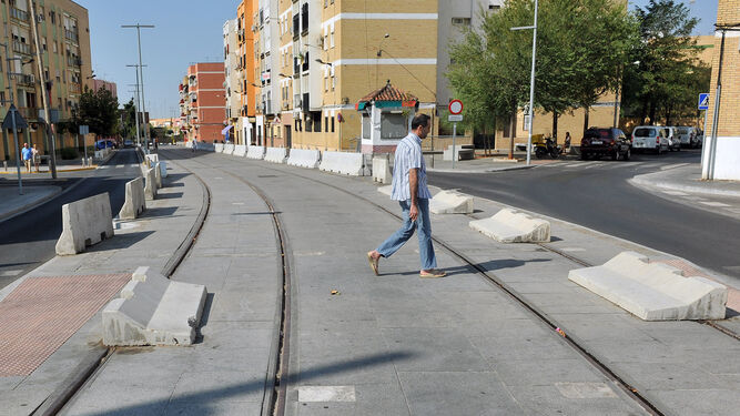 Un hombre cruza por las vías del tranvía en su tramo por el casco urbano de Alcalá de Guadaíra.