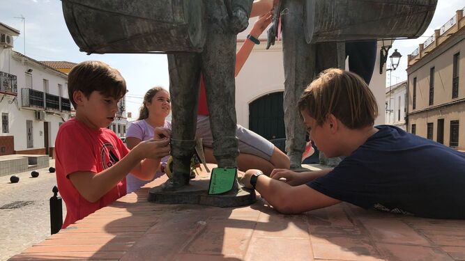 Varios alumnos del CEIP San Pedro de Zúñiga colocan etiquetas con el dinero que cuesta un grupo escultórico.