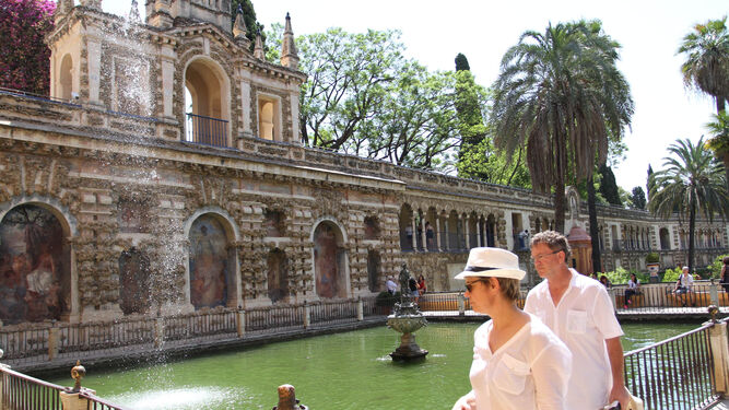 Dos turistas recorren los jardines del Alcázar.