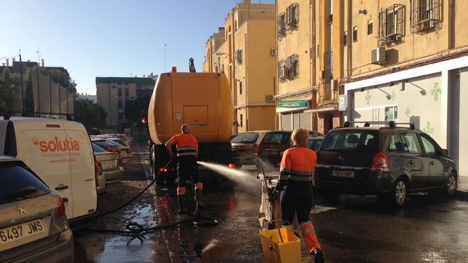 Una pareja de trabajadores de Lipasam limpian una de las calles del barrio de Tartessos.