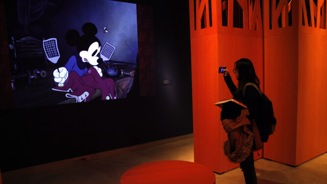 Una visitante fotografía una proyección de Mickey Mouse en la exposición 'Disney. El arte de contar historias'.
