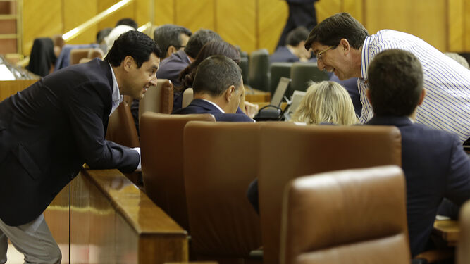 Juanma Morneno y Juan Marín conversan durante un Pleno en el Parlamento.