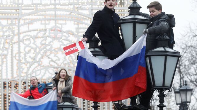Jóvenes manifestantes protestan sobre las farolas ayer en Moscú.