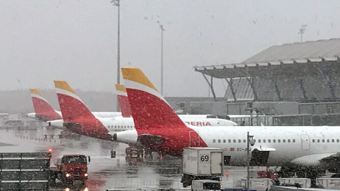 Imagen de tres aviones de Iberia bajo la nieve en el aeropuerto Adolfo Su&aacute;rez- Madrid-Barajas.