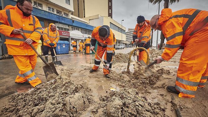 Un grupo de operarios trabajando en la playa de Cádiz.