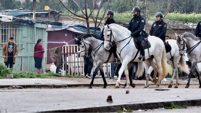 Policías a caballo en el asentamiento chabolista.