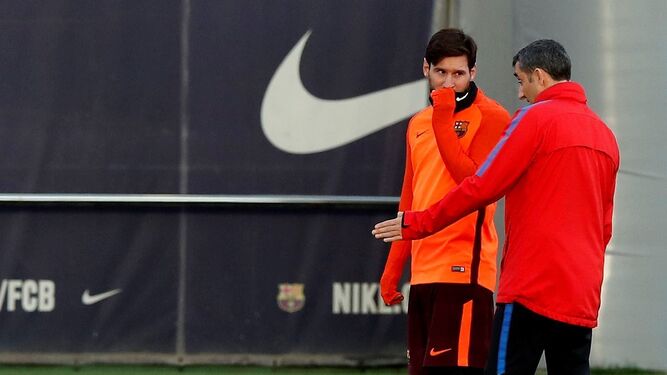 El técnico barcelonista, Ernesto Valverde, da una indicación a Lionel Messi en pleno entrenamiento.