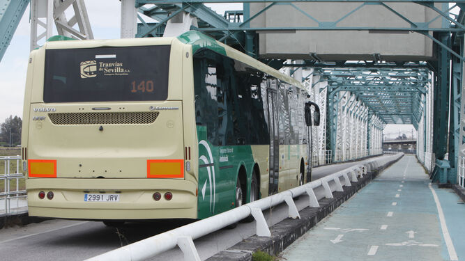 Un autobús del Consorcio de Transportes, de Travías de Sevilla, por el Puente de Hierro de San Juan.