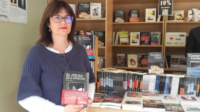 La autora posa con la novela, 'El Juego de la Invención', en la caseta número 13 de la Feria del Libro.