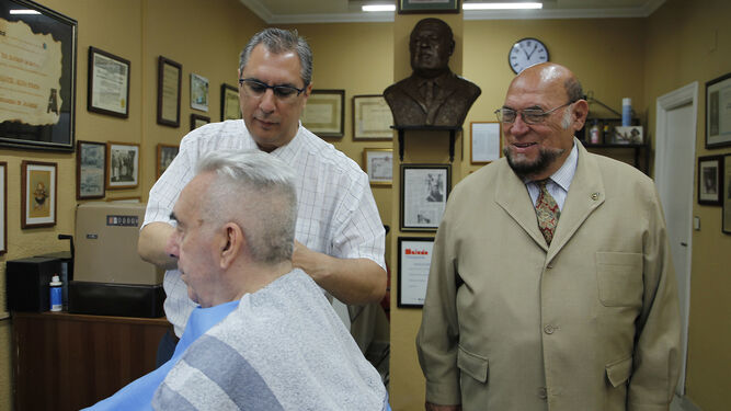 Melado sonríe junto al busto de Méndez Lastrucci mientras su hijo Antonio le arregla el pelo a Rafael León.