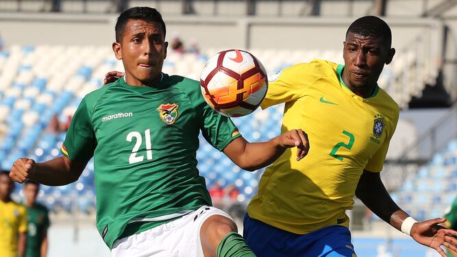El brasileño Emerson disputa el balón con el boliviano Roberto Fernández.