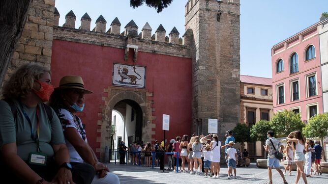 Turistas esperan al sol para entrar en el Alcázar de Sevilla