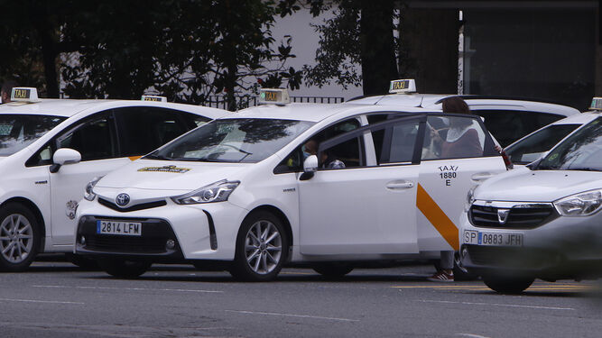 Varios taxis esperan en una parada de taxis