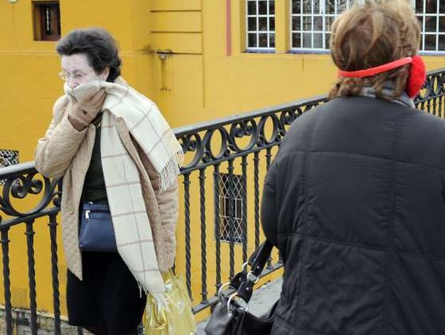 Una mujer se tapa la cara con una bufanda.