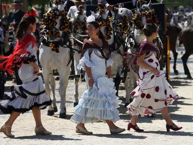 Varias j&oacute;venes vestidas de flamenca cruzan delante de los caballos.

Foto: Antonio Pizarro, Juan Carlos V&aacute;zquez, Juan Carlos Mu&ntilde;oz,  Bel&eacute;n Vargas
