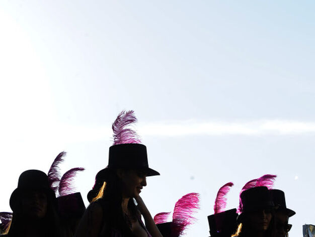 Un grupo de mujeres, ataviadas con sombreros coronados con plumas.