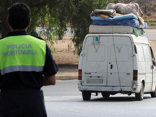 Una furgoneta cargada de enseres personales abandona la carretera de El Copero ante la mirada de un agente de Polic&iacute;a.

Foto: Juan carlos V&aacute;zquez