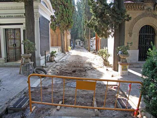 Una valla restringe el paso a una de las calles del cementerio de San Fernando que se encuentra en obras./ Bel&eacute;n Vargas