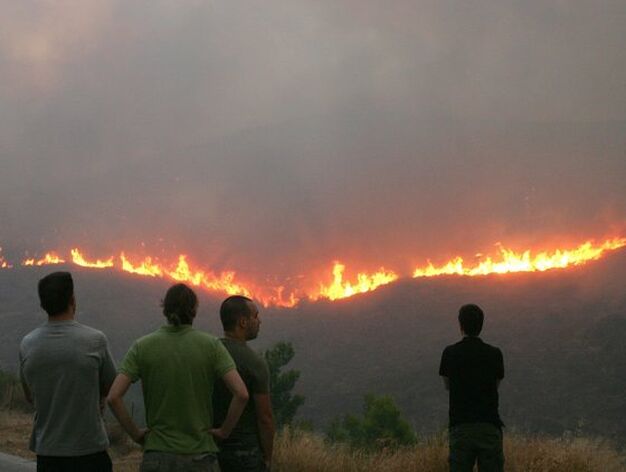 Hombres observan el fuego a 15 kil&oacute;metros de Atenas.

Foto: Efe