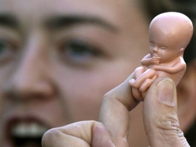 Una mujer ense&ntilde;a una figura que representa a un feto. / EFE