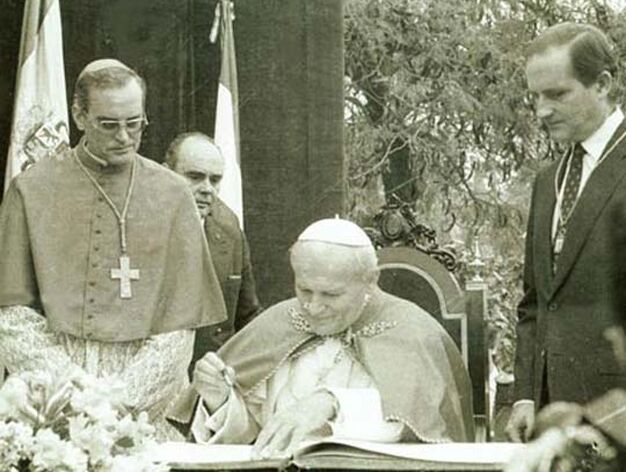 1982: Juan Pablo II en Sevilla. El Papa Juan Pablo II firma en el libro de honor a su llegada a la ciudad. Aparece flanqueado por el alcalde andalucista Luis Uru&ntilde;uela y por monse&ntilde;or Amigo