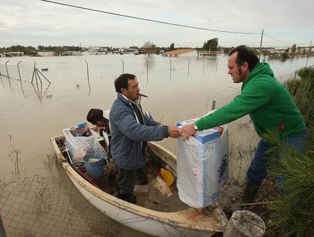 Varios individuos sacan sus pertenencias de sus casas en barcas.

Foto: Juan Carlos Toro