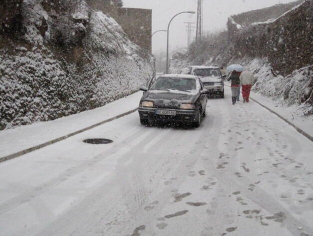 Los coches bajan lentamente una cuesta ante la acumulaci&oacute;n de nieve en la calzada.

Foto: C. Valdivieso