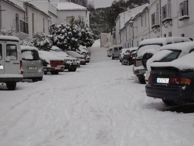Una calle del municipio totalmente blanca con los coches aparcados cubiertos de nieve.

Foto: C. Valdivieso