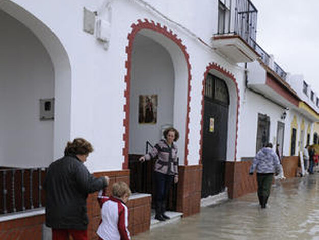 Una mujer anda con un ni&ntilde;o de la mano por una calle de Tocina cubierta por el agua.

Foto: Juan Carlos V&aacute;zquez