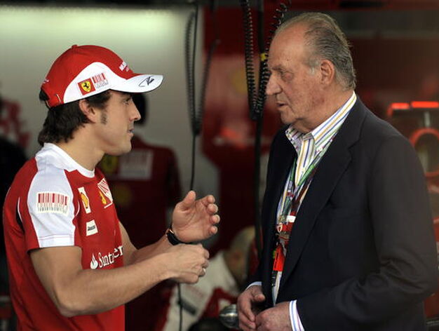 Fernando Alonso departe con el rey Juan Carlos antes de la carrera. / AFP