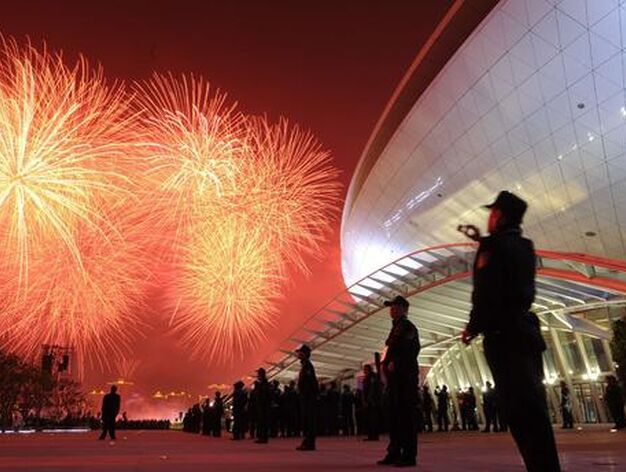 Un guardia chino fotograf&iacute;a los fuegos artificiales. 

Foto: Peter Parks (AFP Photo)