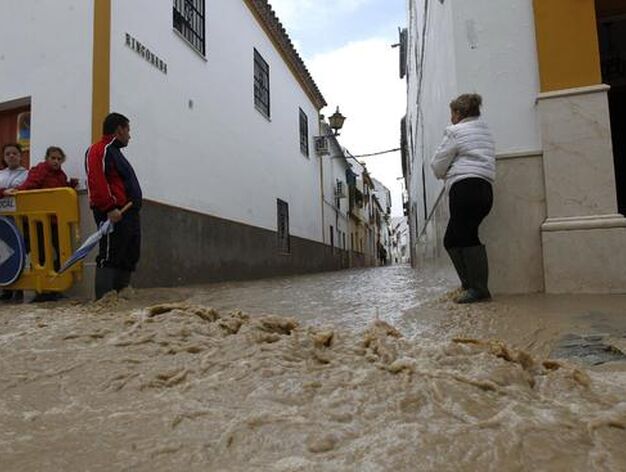 Los vecinos contemplan las corrientes de agua que inundan las calles de &Eacute;cija.

Foto: Antonio Pizarro